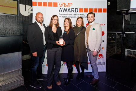 Gruppe von Männern und Frauen die einen VAMP Award halten 