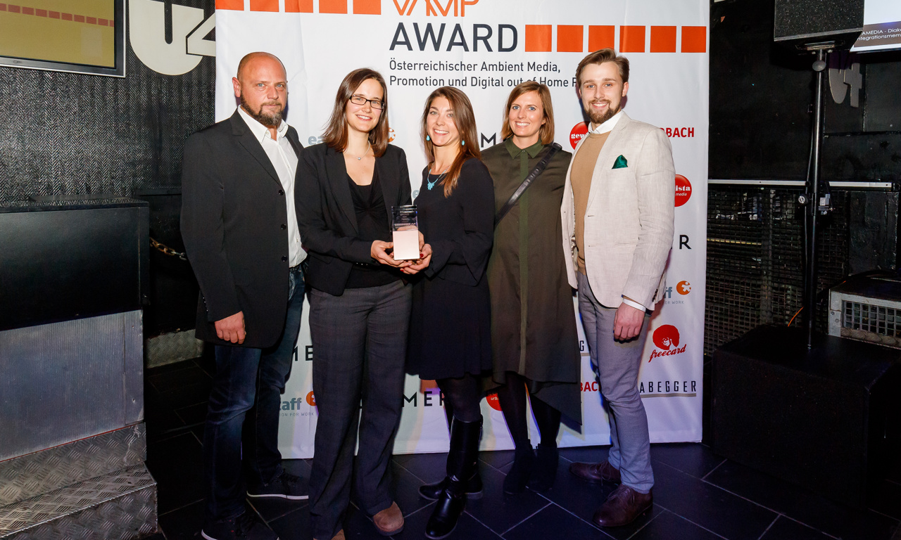Gruppe von Männern und Frauen die einen VAMP Award halten 
