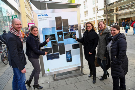 V.l.n.r.: Bildunterschrift: Marcus Zinn (Director Client Service & Sales, EPAMEDIA), Judith Ha-berlehner (Head of PR CEE, HMD Global), Margot Sandtner (Director Client Lea-dership, Mindshare), Petra Elsinger (Manager Client Leadership, Mindshare) und An-drea Pany (Client Service Manager, EPAMEDIA) vor dem interaktiven Citylight)