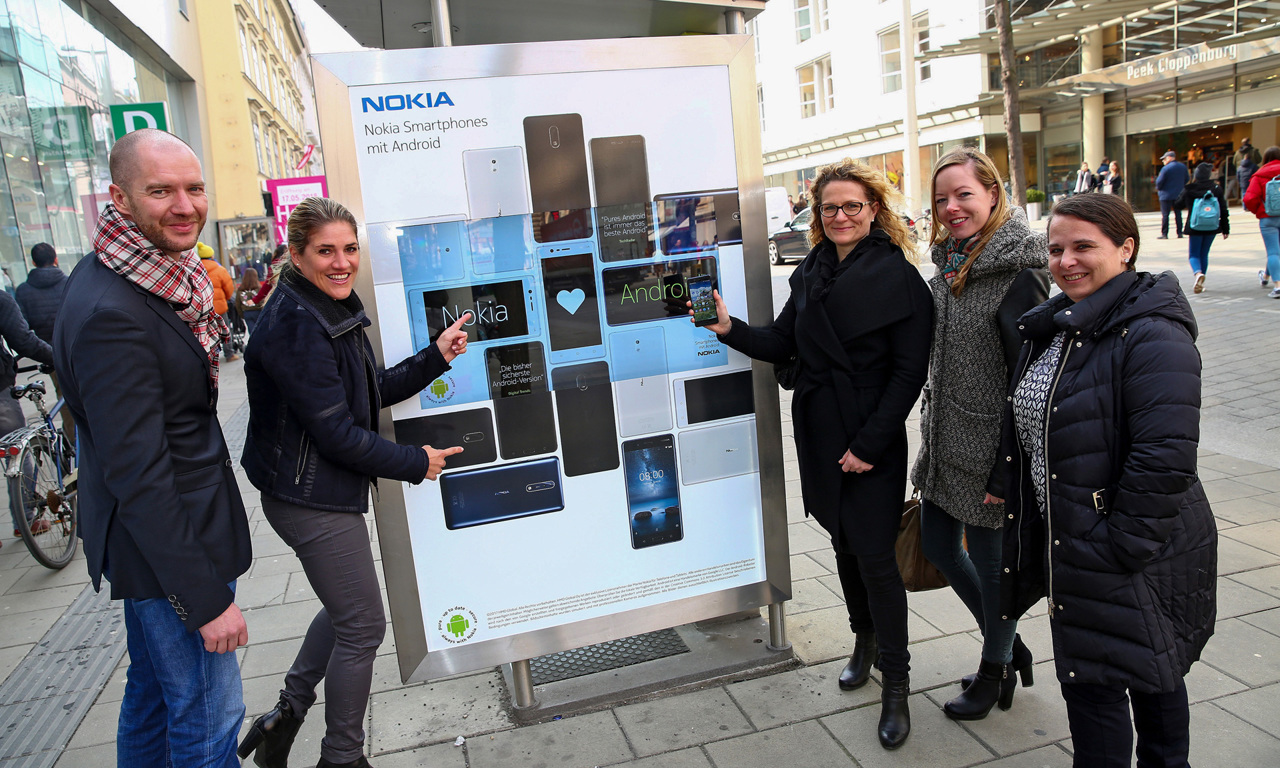 V.l.n.r.: Bildunterschrift: Marcus Zinn (Director Client Service & Sales, EPAMEDIA), Judith Ha-berlehner (Head of PR CEE, HMD Global), Margot Sandtner (Director Client Lea-dership, Mindshare), Petra Elsinger (Manager Client Leadership, Mindshare) und An-drea Pany (Client Service Manager, EPAMEDIA) vor dem interaktiven Citylight)